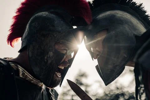 Duel between two screaming in rage ancient warriors in battle dress. Stock Photos