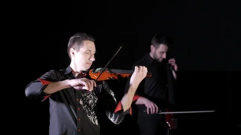 Duet of young people playing the electric cello and electric violin, isolated Video stock 107871353