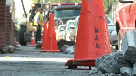 Dugup sidewalk with orange work cones and bulldozer city tree planting Stock Footage 11024267