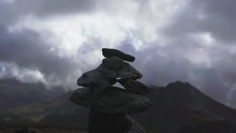 A dull stone cairn with cloudy mountain background Stock Footage 143261195