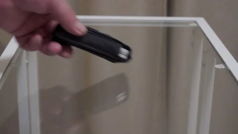 Dull Thud: Black Fabric Case with Folding Knife Dropped onto Glass Table. Stock Footage 320809404