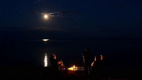 DULUTH MN - 15 MAY 2022: People enjoy lakeside fire pit under full moon. Stock Footage 201213236