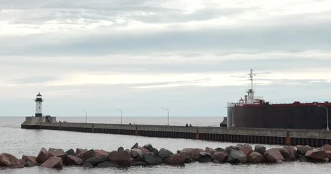 DULUTH, MN - 17 JUN 2024: Ship leaves Duluth past lighthouses at canal Stock Footage 282621991