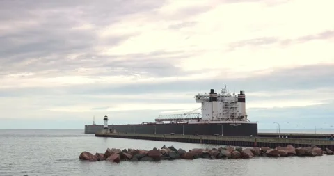 DULUTH, MN - 17 JUN 2024: Ship leaves Duluth past lighthouses at canal Stock Footage 282621997