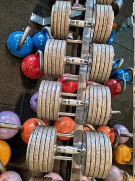 Dumbbell rack with different weights in the gym Stock Photos