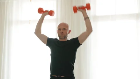 Dumbbell shoulder press exercise performed by man at home. High quality shot sho Video stock 331750048