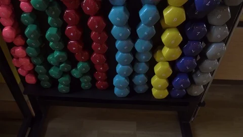 Dumbbells and rollers for massage on racks in the gym Stock Footage 115055115