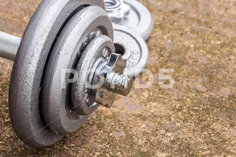 Dumbbells on cement floor Stock Photos