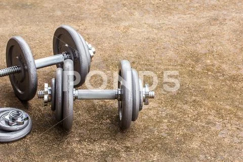 Dumbbells on cement floor Stock Photos