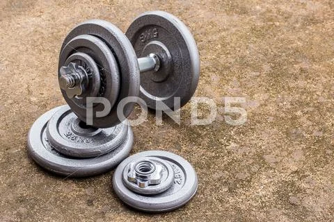 Dumbbells on cement floor Stock Photos