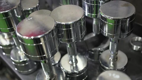 Dumbbells of different weights and sizes stand on tabletop in gym Stock Footage 291335828