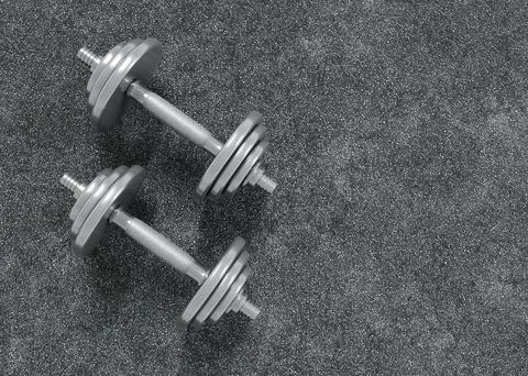Dumbbells on grey textured background Illustrazione stock