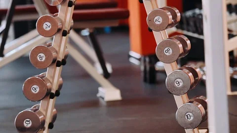 Dumbbells in the gym are on a red rack Stock Footage 128233452