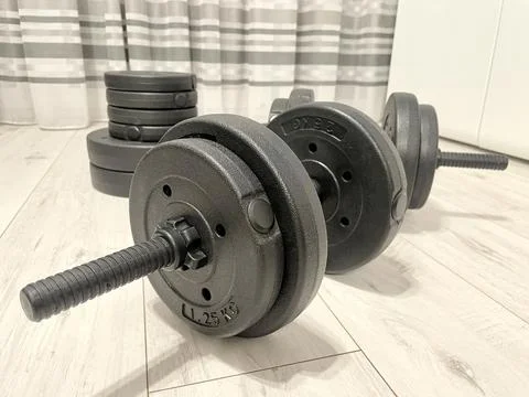 Dumbbells lying on floor, home workout and fitness during lockdown concept Stock Photos