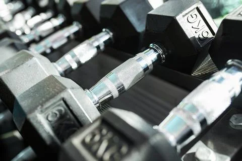 Dumbbells in a rack at the gym. Free weights closeup. Stock Photos