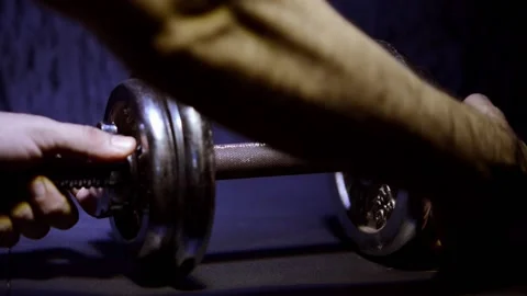Dumbbells shot on a dark blue background sprayed and dissinfected Видео 150780148