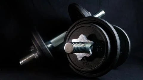 Dumbbells for strength training on dark studio background Stock Photos