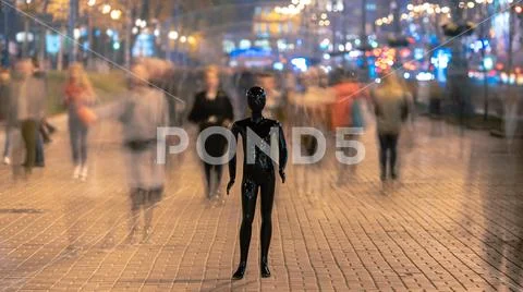 The dummy standing on the evening street with people Stock Photos