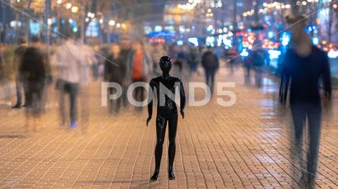 The dummy standing on the evening street with people Stock Photos