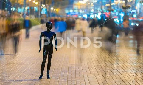 The dummy standing on the street among the stream of people Stock Photos