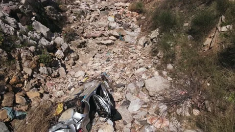 Dump with garbage and broken car on the rocks among cliffs, view from above Video stock 158299887