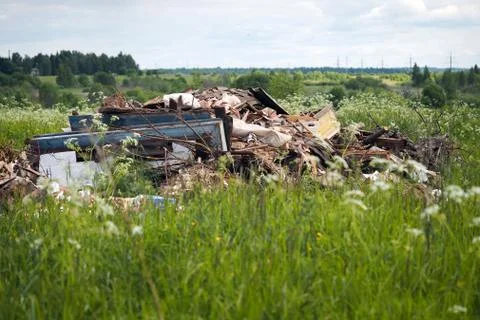 Dump garbage in the field. The concept of environmental pollution Stock Photos