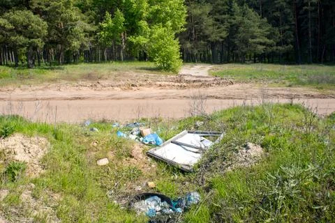 Dump garbage near the forest. Illegal dump near the country sand road.  Trash Stock Photos