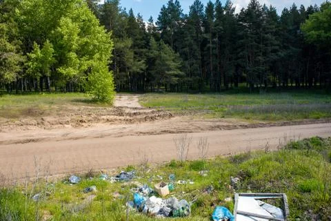 Dump garbage near the forest. Illegal dump near the country sand road.  Trash Stock-Fotos