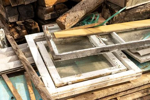A dump of old wooden window frames with glass. Recycling of materials Stock Photos