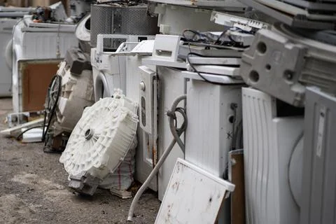 Dump or collection point for broken washing machines and spare parts on ground Stock Photos