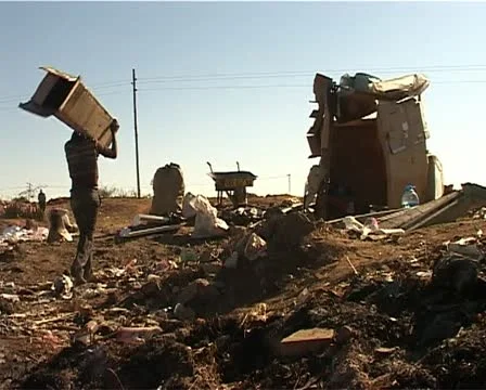 Dump site kid brings box to his shak Stock Footage 11498558