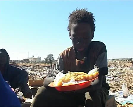 Dump site kid eating. Stock Footage 11498784