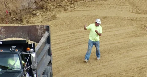 Dump truck being guided on construction site - 4k Stock Footage 53505778