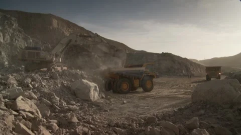 A dump truck being loaded by another construction vehicle Stock Footage 312400437