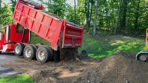 Dump Truck Unloading Dirt During a Construction Project Near a Forest Stock Footage 115625066