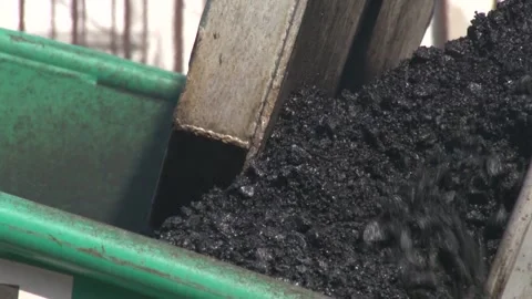 Dump truck unloading new, hot asphalt into an asphalt paver. Video stock 234209063