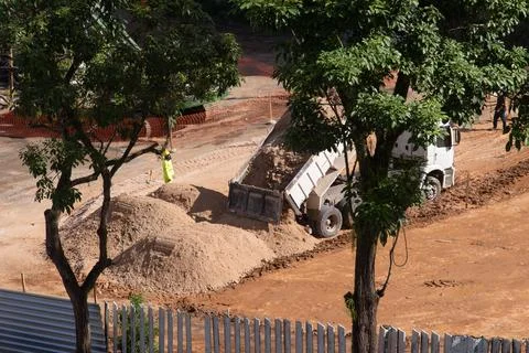 Dump truck unloading sand at construction site Photos