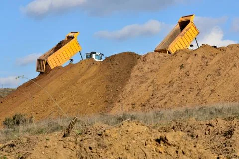 Dump truck unloading soil during road works Stock Photos
