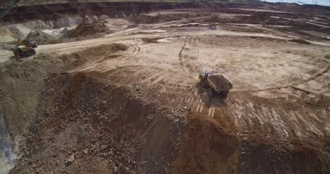 Dump truck unloads at large pit among mining machinery Stock Footage 130383952