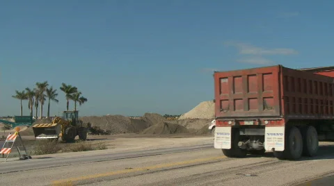 Dump trucks and loader working in a construction site - Editorial. Stock Footage 348696