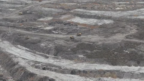 Dump trucks going back and forth transporting coal in a large mining area Stock Footage 332599626