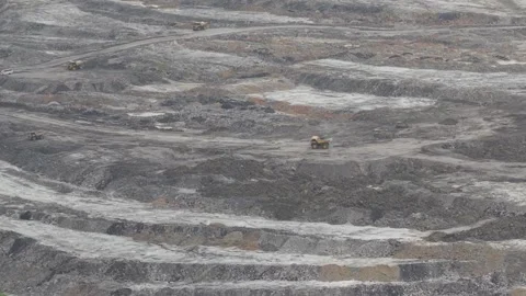 Dump trucks going back and forth transporting coal in a large mining area Stock Footage 332599682