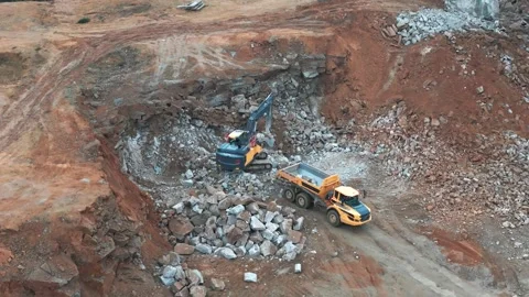 Dump trucks move large stones to a crusher, loaded by an excavator. The qua.. Stock Footage 295953712