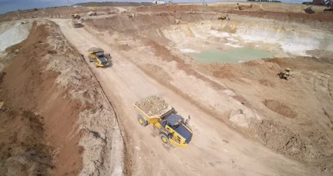Dump trucks with overburden ground drive to large quarry Stock Footage 130384425