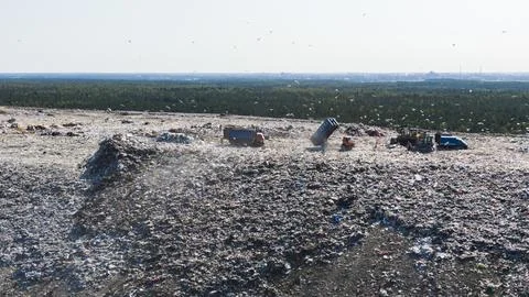 Dump trucks unload household garbage in a giant landfill in the countryside Foto stock