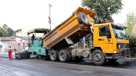 Dumper and machine for paving in work process during roadworks by Pakito. Stock Footage 41477360