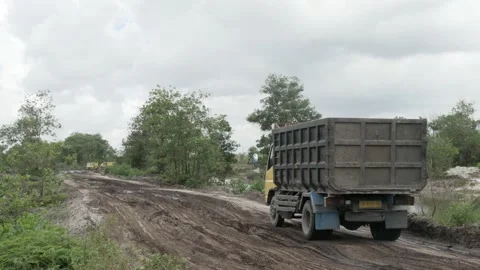 Dumper trucks on muddy road, transporting sand from quarry Stock Footage 160304095