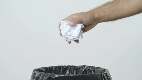 Dumping crumpled paper into the trash. Overflowing waste paper in garbage bin. j Stock Footage 144660861
