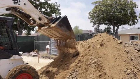 Dumping dirt with skid steer at a construction site Stock-Footage 228794760