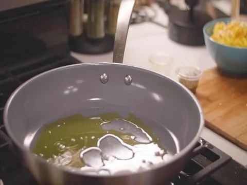 Dumping onions into frying pan in slow motion Video stock 80562197